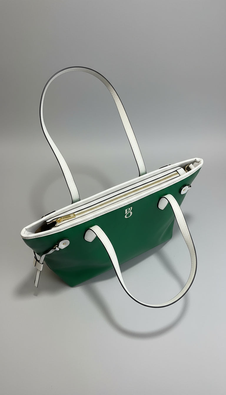 Green handbag with a white strap on a wooden surface