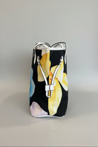Black bag with yellow floral design on a marble surface
